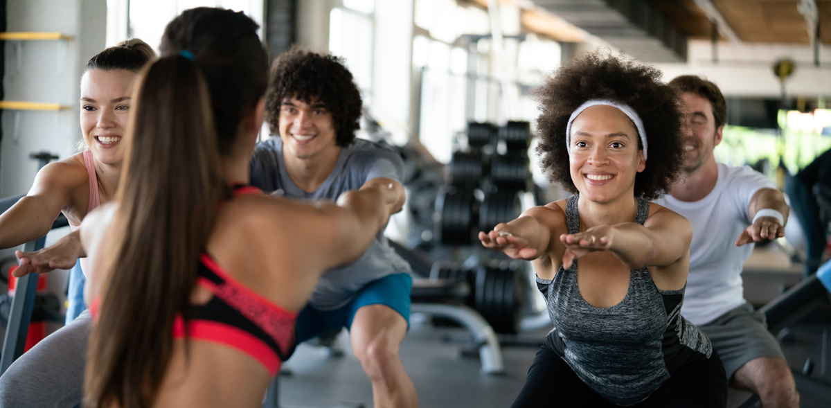 Motivated Group Fitness Training at Gym Group fitness class at a modern gym, focused on strength training and wellness.
